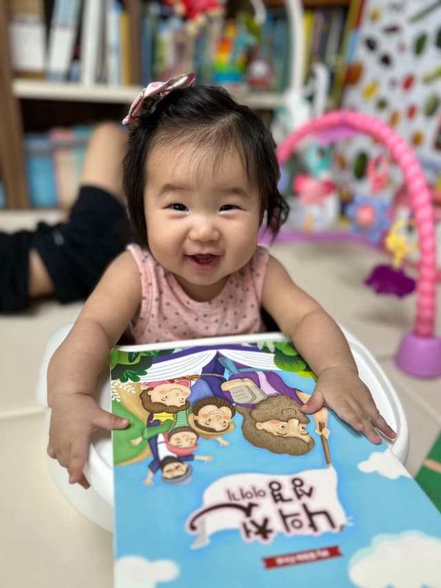 영아 교재를 보며 웃는 아이