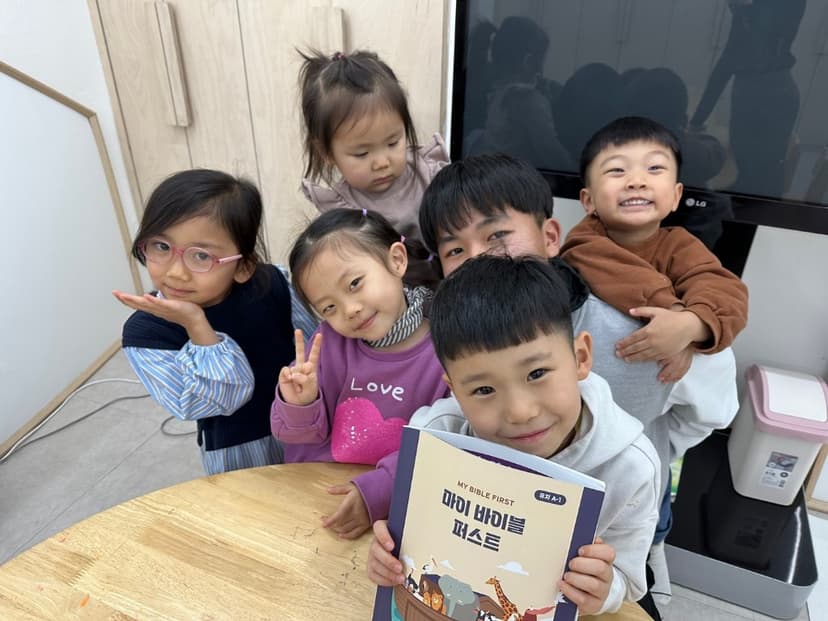 유치 교재를 들고 있는 어린이들